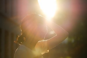 Woman with short brown hair backlit by afternoon sunlight